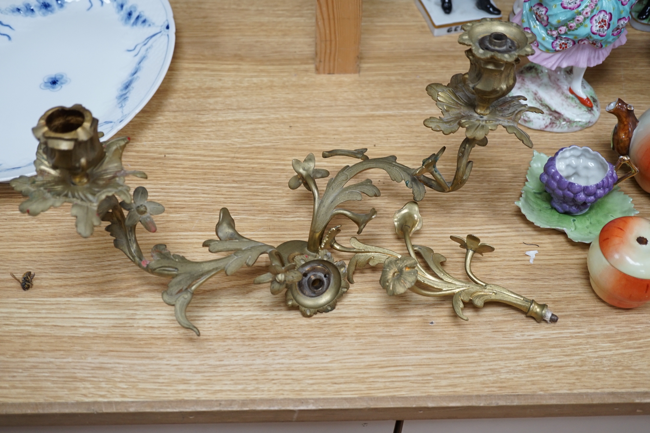 A pair of Sevres style porcelain and brass rococo-style two branch candelabra, hand painted with exotic birds, 50cm high